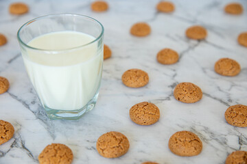 Amaretti cookies and glass of milk drink. Small soft Italian traditional sweet-bitter pastry dessert.