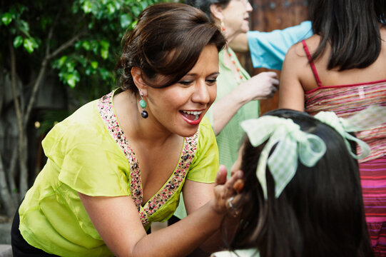 Woman pinching young girl's cheeks
