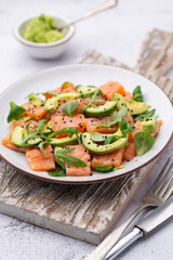Fresh salmon salad with avocado,  for keto and low carb diet. Rusty background, top view, copy space.