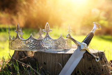 mysterious and magical photo of silver king crown and sword in the England woods. Medieval period...