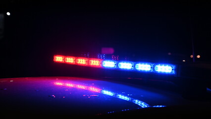 Police emergency lights flash at night. Car accident. Crime scene.  Flashing blue and red lights on...
