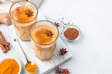 Indian latte with turmeric and cinnamon on a light background.