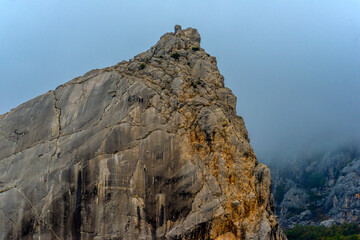 Fototapeta premium Stony slopes of mountain in dense fog.