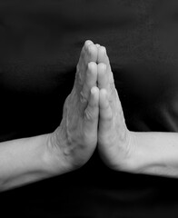 praying to god with hands together with dark background stock photo