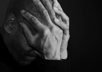 man praying to god with hands together on dark background stock photo