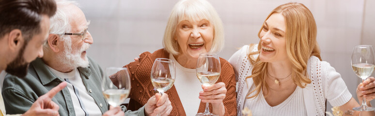 cheerful family toasting with wine glasses during easter celebration, banner.