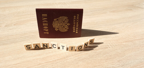 passport of citizen Russian Federation, word sanctions on wooden letters, concept of economic...