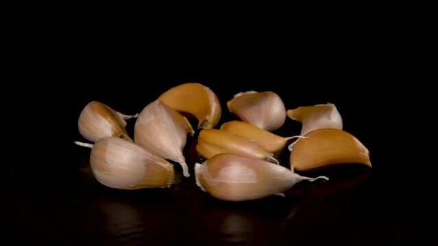 garlic cloves rotate on a black background, close-up 