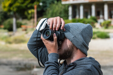 A person looking through a camera taking a photograph. Learning photography course lesson.