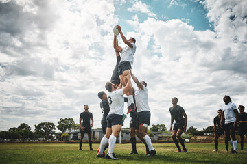Reach for the sky. Shot of two rugby teams competing over a ball during a line out of a rugby match outside on a filed. - obrazy, fototapety, plakaty