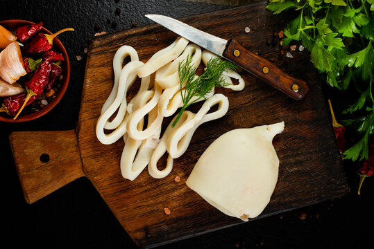 Slicing of boiled calamar on a cook-table