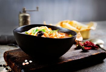 Pan Asian traditional seafood soup with mussels, calamari, mushrooms served with fresh parsley herbs
