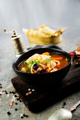 Pan Asian traditional seafood soup with mussels, calamari, mushrooms served with fresh parsley herbs