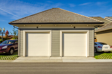 Garage door in luxury house with trees and nice landscape