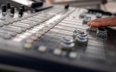 sound technician hand working on a professional sound mixer - selective focus