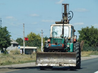 Old tractor excavator on the road.