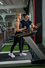 man and woman athletes promising coaches are engaged in two in the gym so as not to lose shape