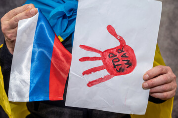 Ukrainian patriot wrapped in Ukrainian flag opposes Russia's war with Ukraine.