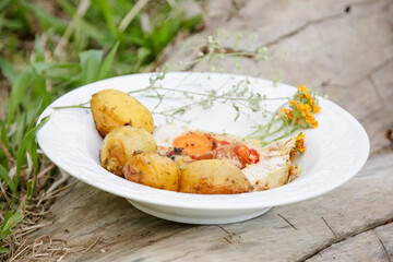 Loin in exotic dish with potato and onion herbs.
