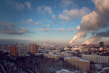 View of the big city from above. Metropolis under high blue sky with white clouds.