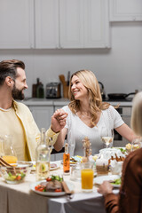 happy couple holding hands and looking at each other while celebrating easter at home.