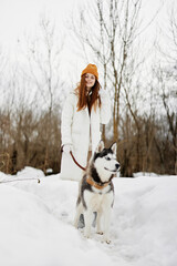 woman winter clothes walking the dog in the snow Lifestyle