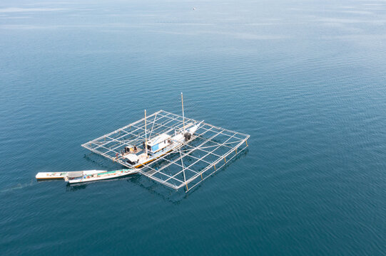 An Indonesian bagan, a fishing vessel that uses nets and lights to attract fish, floats in a calm bay in Indonesia. This type of fishing vessel usually catches small fish, squid, and shrimp.