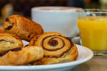 Continental breakfast of assorted pastries including croissant, Danish and cinnamon swirl served with coffee and orange juice