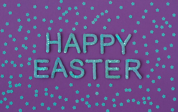 Inscription of "Happy Easter" embroidered with blue sequins on purple textured background with scattered random sequins in form of flowers