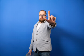 Naklejka premium Man showing finger up. Stop aggression concept. Isolated on blue background.