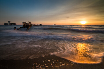 Fototapeta Morze, wschód słońca, zachód słońca, molo, plaża, kutry rybackie, piękny krajobraz nadmorski. obraz