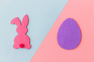 Happy Easter! Colorful Easter egg and bunny on purple and pink background, flat lay with space for text. Purple and pink artificial egg and bunny decor. Creative Easter hunt concept