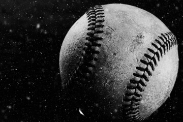 Old baseball ball close up in black and white for nostalgic sports background in shallow depth of field.