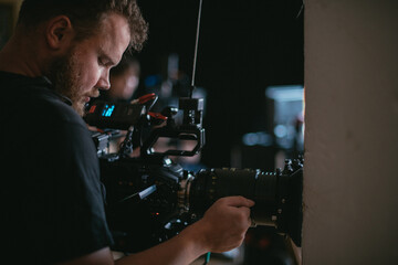 Director of photography with a camera in his hands on the set. Professional videographer at work on filming a movie