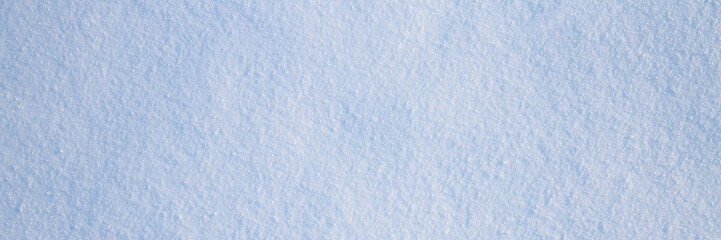 Natural snow texture. The surface of clean fresh snow. Snowy ground. Winter background with snow patterns. Wide panoramic texture for background and design. Perfect for Christmas and New Year design.