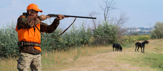 Hunter man in camouflage with a gun during the hunt in search of wild birds or game. Autumn hunting...
