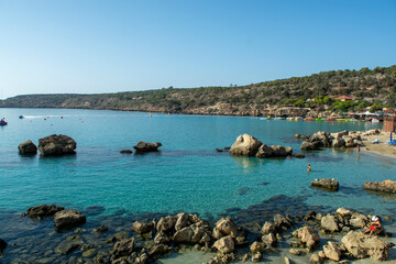 Fototapeta na wymiar Crystal clear blue water of Mediterranean sea and yellow rocks in on Konnos beach near Protaras, Cyprus