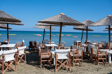 Beach unbrellas and chairs on sunny sandy beach Lady's mile in Akritori, Cyprus