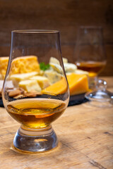 British drinks and food, glasses of Scotch whisky and cheeses collection, blue Stilton, Scottish coloured and English matured cheddar cheeses