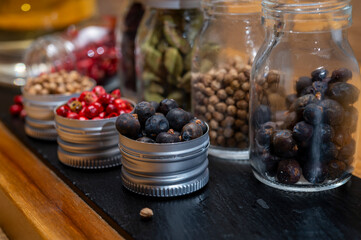 Professional set of gin spices in small bottles, pink pepper, hibiscus flowers, juniper berries,...