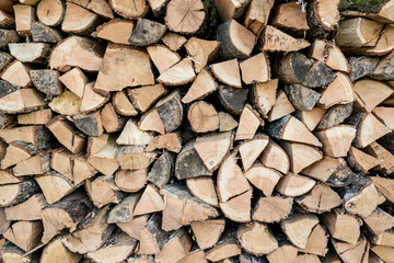Background of stacked chopped wood logs. Pile of wood logs ready for winter. Wooden stumps, firewood stacked in heap