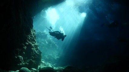 cave diving underwater scuba divers exploring caves and having fun ocean scenery sun beams and rays background - Powered by Adobe