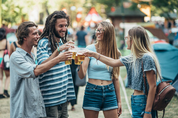 Friends drinking beer and having fun at music festival