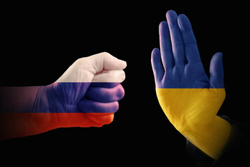 Hands with the flags of Russia and Ukraine, one makes a fist, the other shows a stop gesture,...
