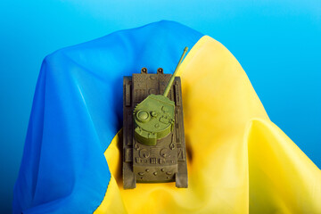 military tank lying on the Ukrainian blue-yellow flag. victory concept. The concept of ending the...