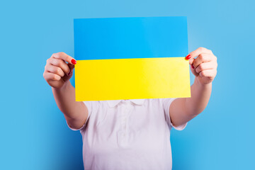 A young Ukrainian girl t holds  a yellow-blue Ukraine flag. Go peace concept. Pray for Ukraine....