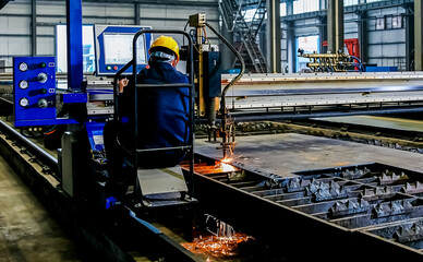 Asian worker is operating monitor equipment control machine inside factory