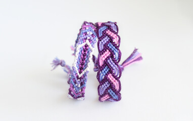 Woven DIY friendship bracelets handmade of embroidery bright thread with knots on white background