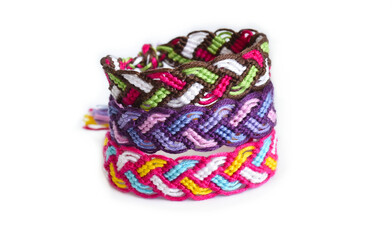 Woven DIY friendship bracelets handmade of embroidery bright thread with knots on white background