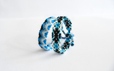 Woven DIY friendship bracelets handmade of embroidery bright thread with knots on white background